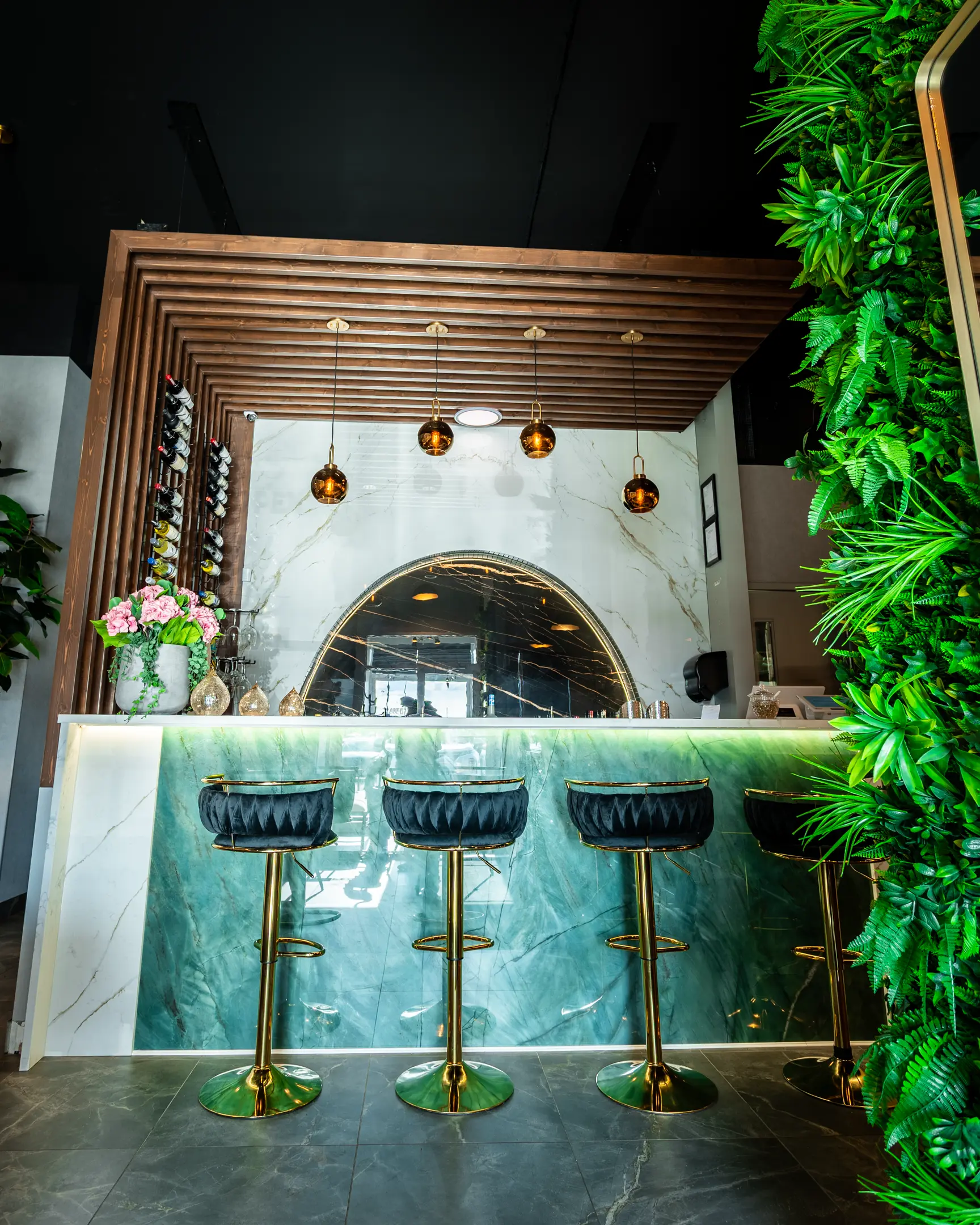 Full bar with green marble counter and gold stools at Masala Theory Calgary SE