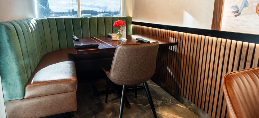Green booth seating by the window at Masala Theory Indian Bistro in Calgary SE