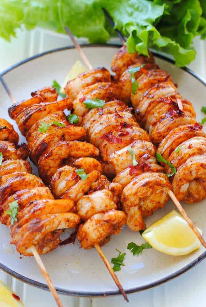 Tandoori Shrimp skewers charred in the clay oven and served with lemon